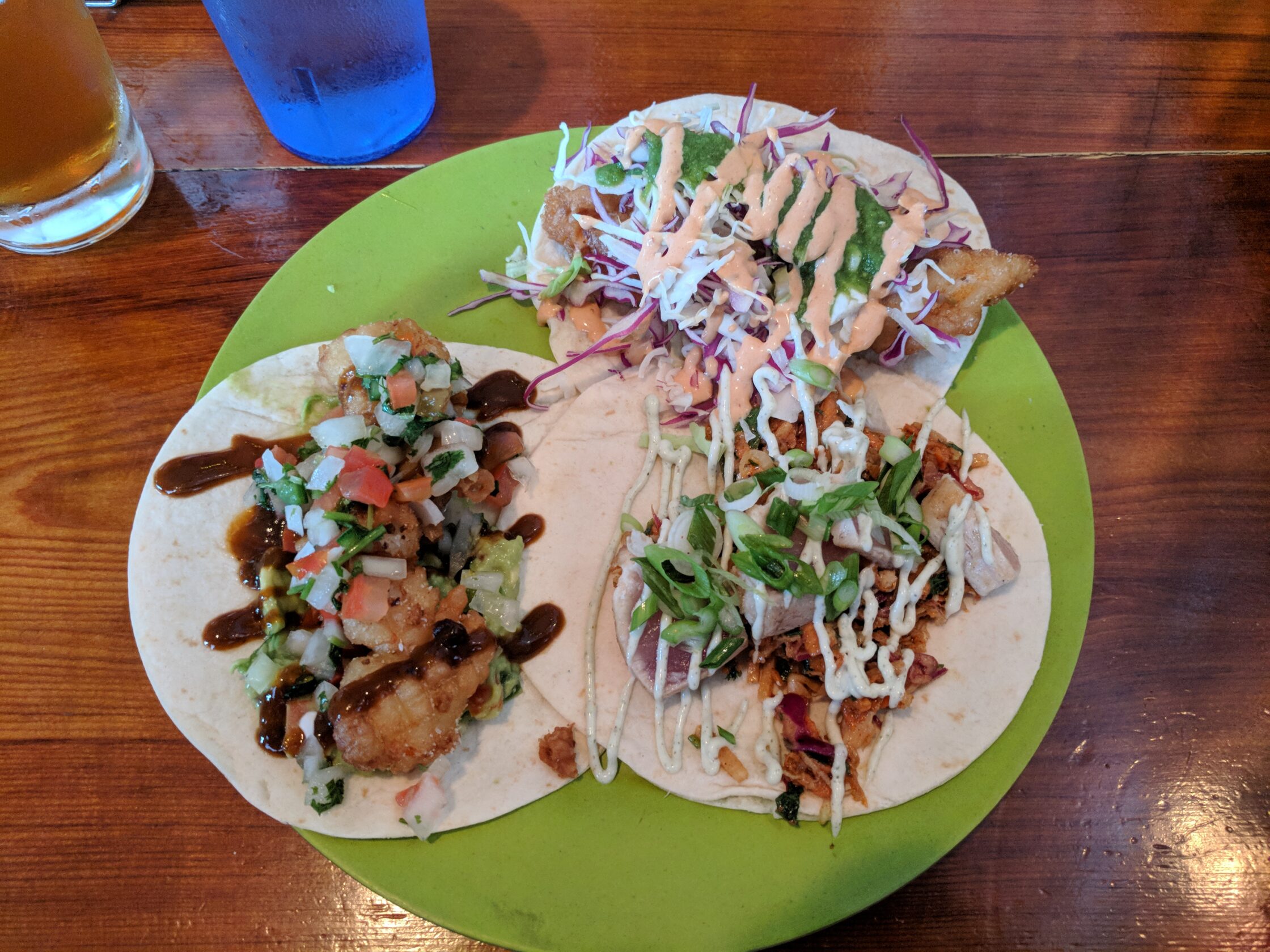 A plate with 3 different types of fish tacos.